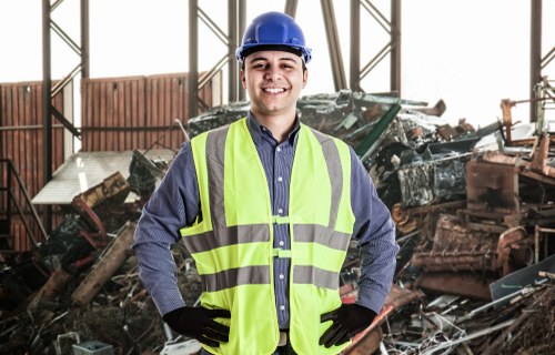 Gloved hands securing a waste container with safety gear visible